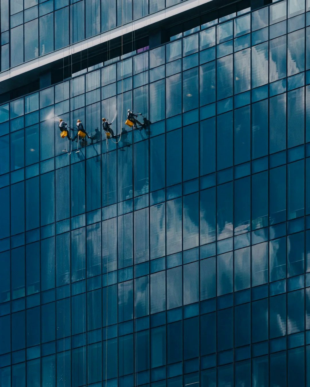 A modern cleaning tool used to clean a large glass window with a clear outdoor view.